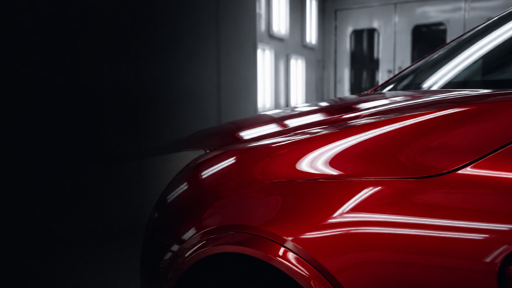 Conceptual red automotive panel in a refinishing workshop